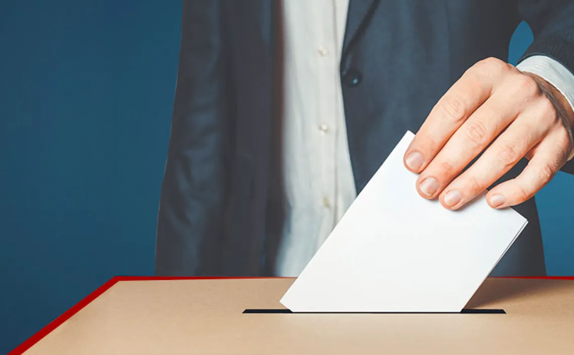 Person in suit casting vote into ballot box